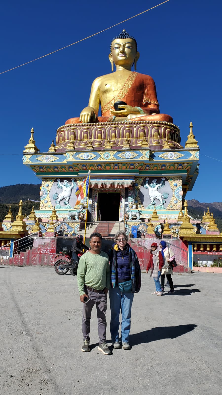 Robert and Odile with the giant golden Buddha statue above Tawang, Arunachal Pradesh
