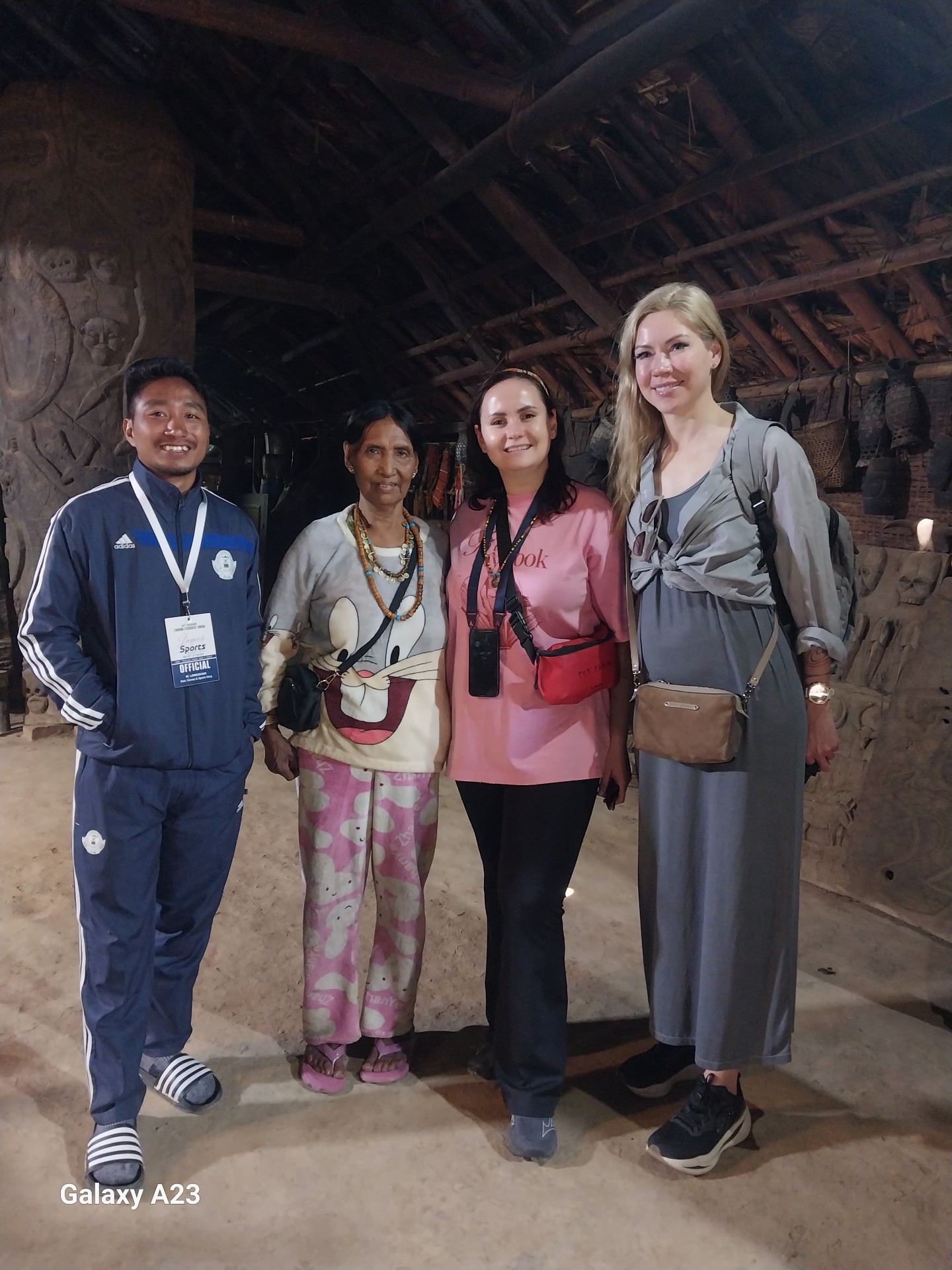 Inside a traditional Konyak longhouse in Mon district, Nagaland, with a village elder and the travellers
