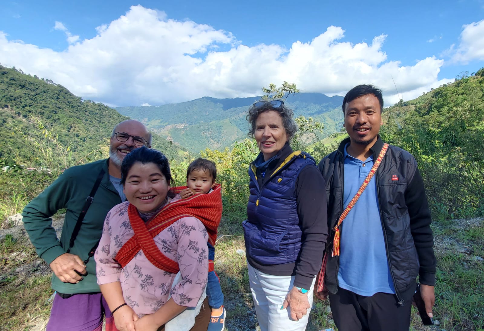 Robert, Odile, guide Pradeep and a young Naga mother with her baby against the Nagaland hills near Kohima