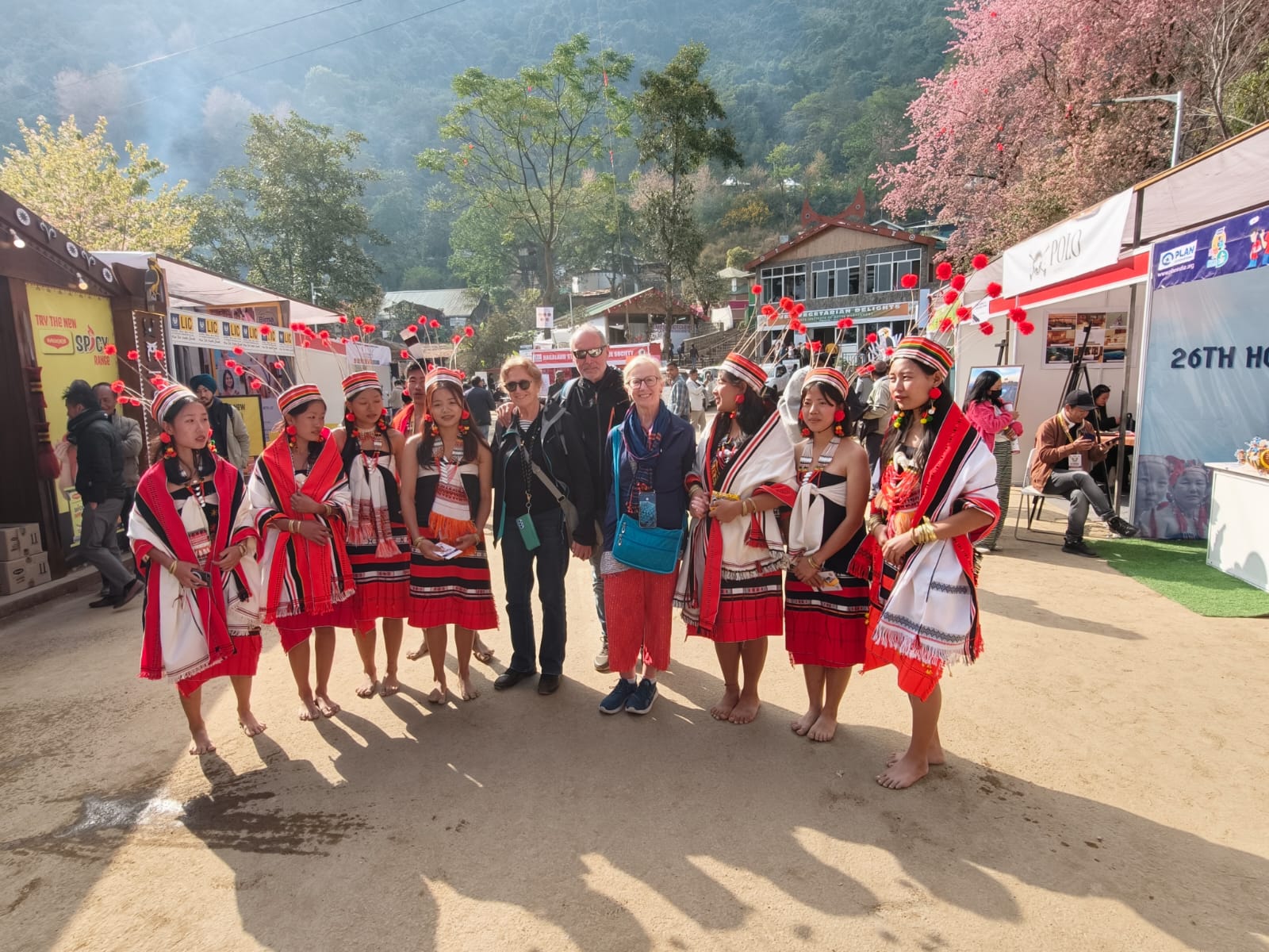 Thierry with young Naga women in traditional red and white attire at the Hornbill Festival craft bazaar