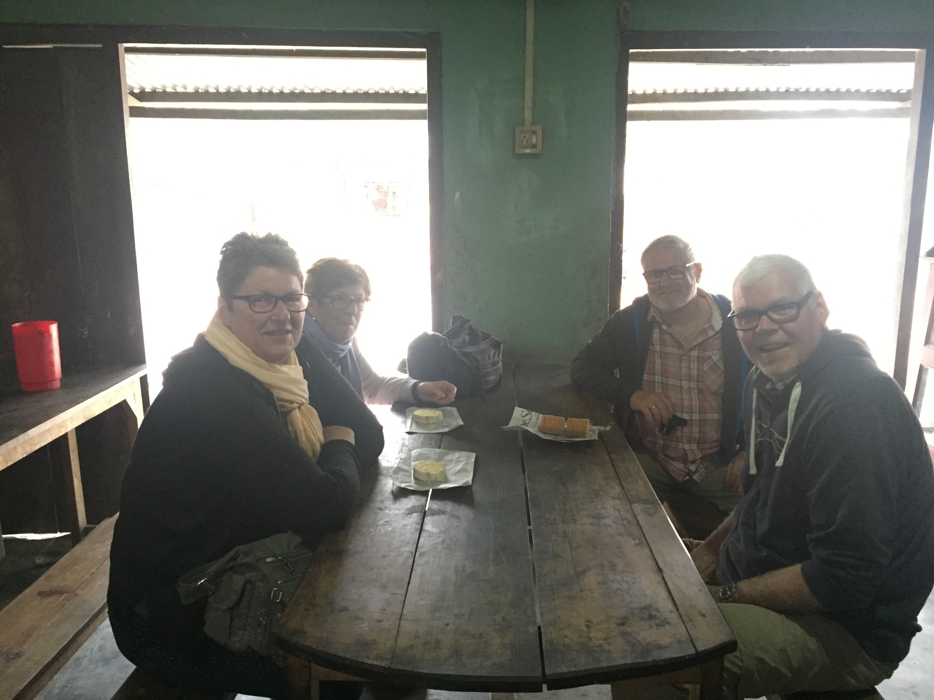 Mr. Buchner and his three friends from Germany sitting around a long wooden table at a roadside tea stop in Meghalaya