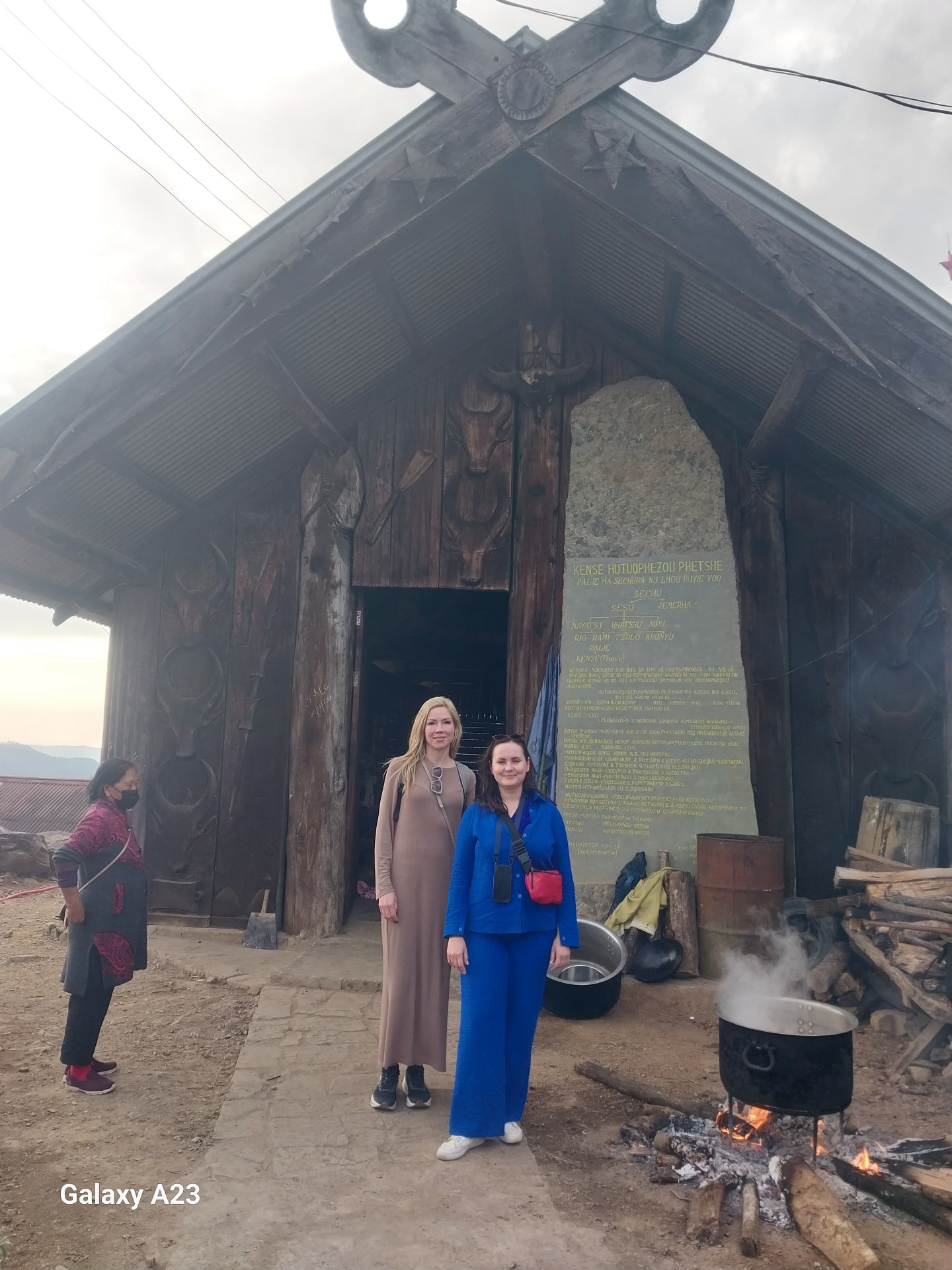 Traditional Angami Naga house with carved mithun heads and a wood-fire cooking pot at Touphema